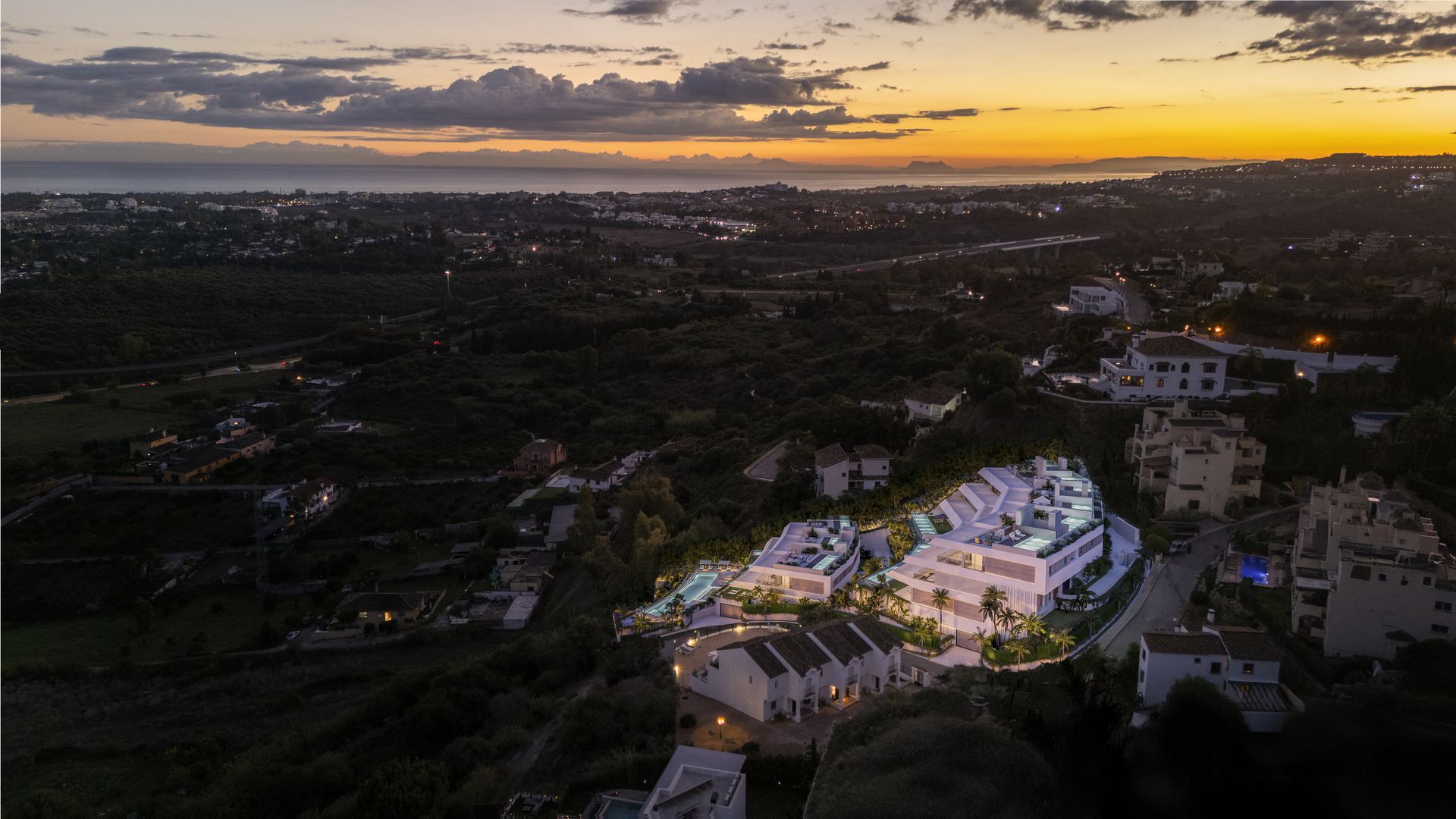 Aerial developer visual showing Altos de Marbella within its wider Marbella East setting at twilight