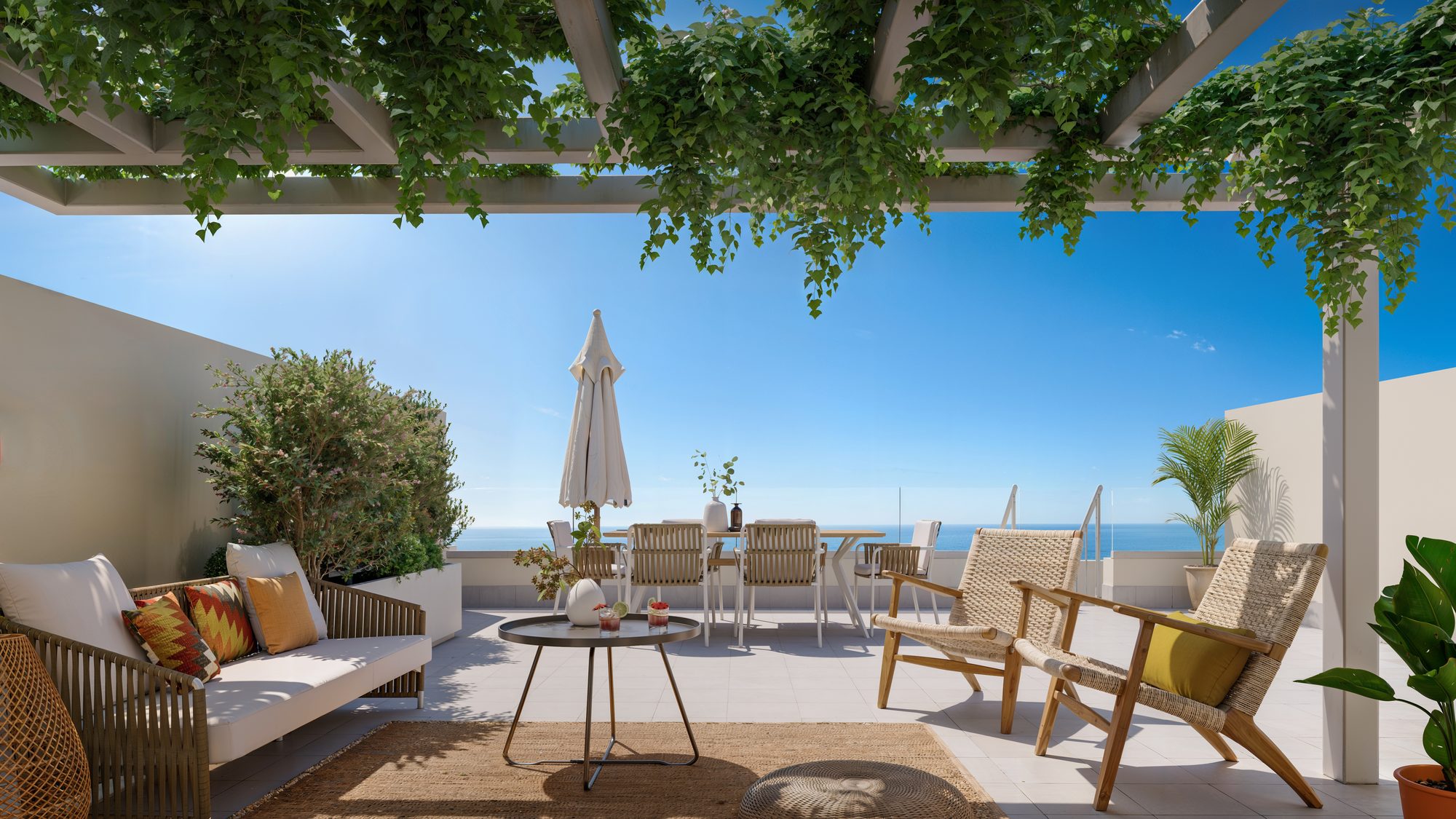 Visualisierung des Bauträgers: eine Terrasse unter einer bepflanzten Pergola, mit Sofa und Esstisch