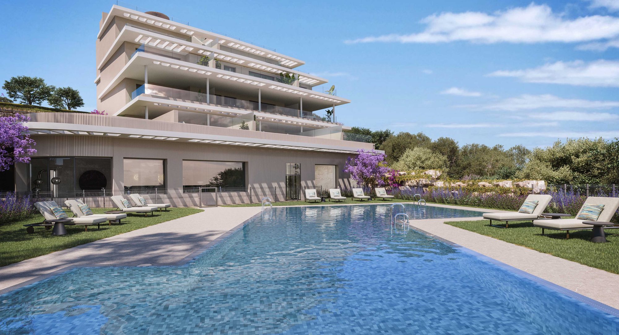 La piscina comunitaria frente a los bloques blancos escalonados bajo un cielo azul
