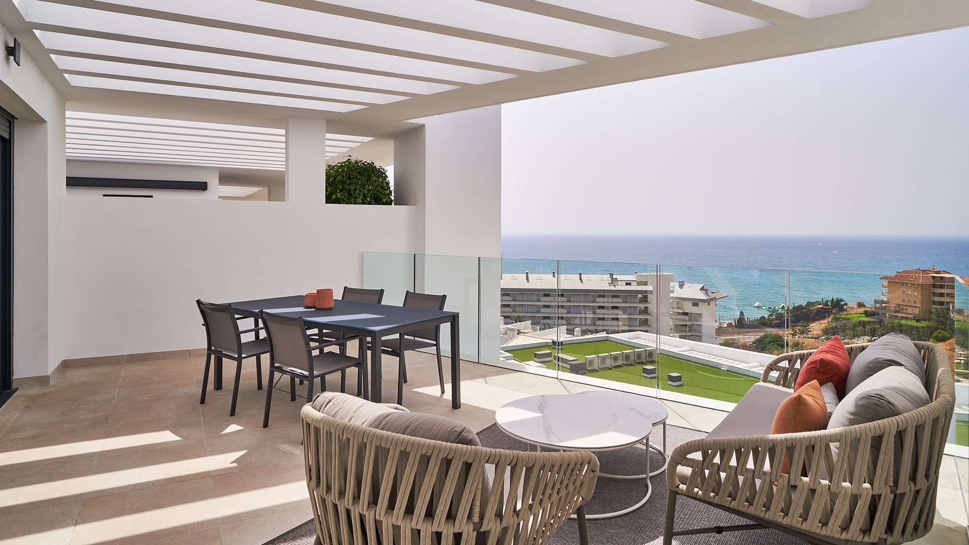 Überdachte Terrasse mit Esstisch, Loungebereich und Blick aufs Meer