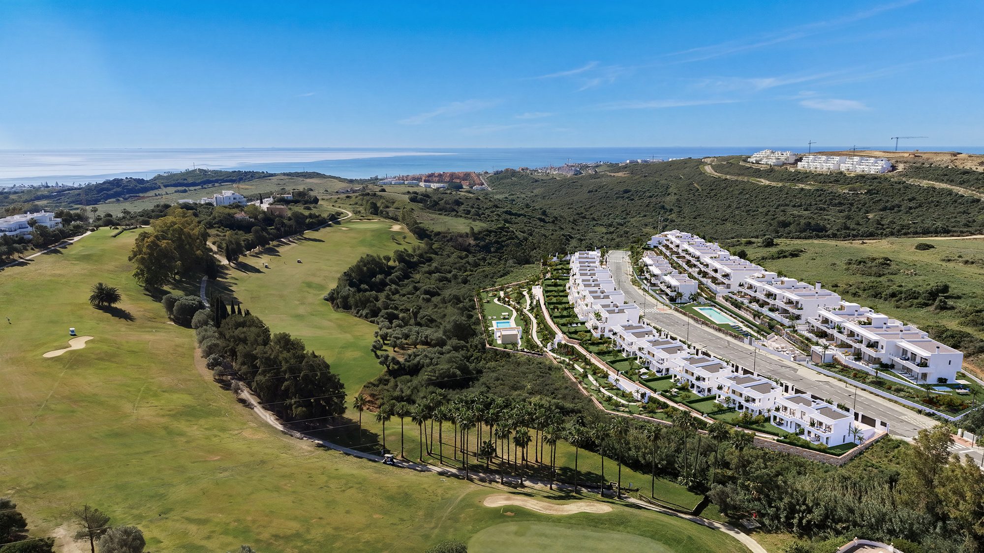 Computergegenereerd luchtbeeld van de rijen witte halfvrijstaande woningen naast een golfbaan, met de zee in de verte