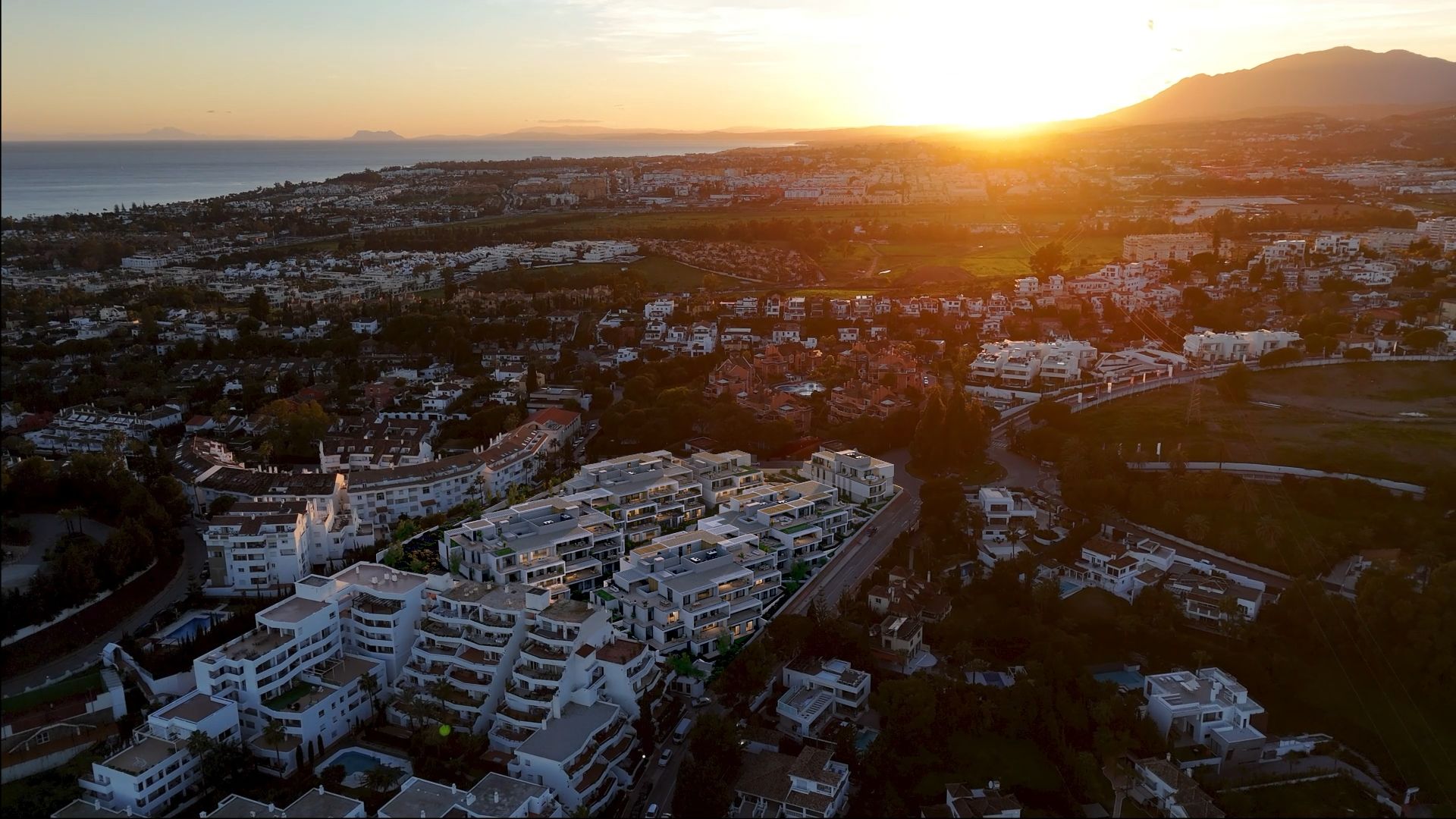 Aerial developer visual showing Vega Verde Residences within its Nueva Andalucia Golf Valley setting at sunset