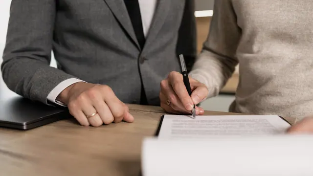 Buyer signing an agreement with professional guidance